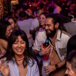 People enjoying a vibrant pub crawl in Hamburg’s Reeperbahn, smiling, dancing, and socializing at a packed nightclub – best nightlife experience in Hamburg