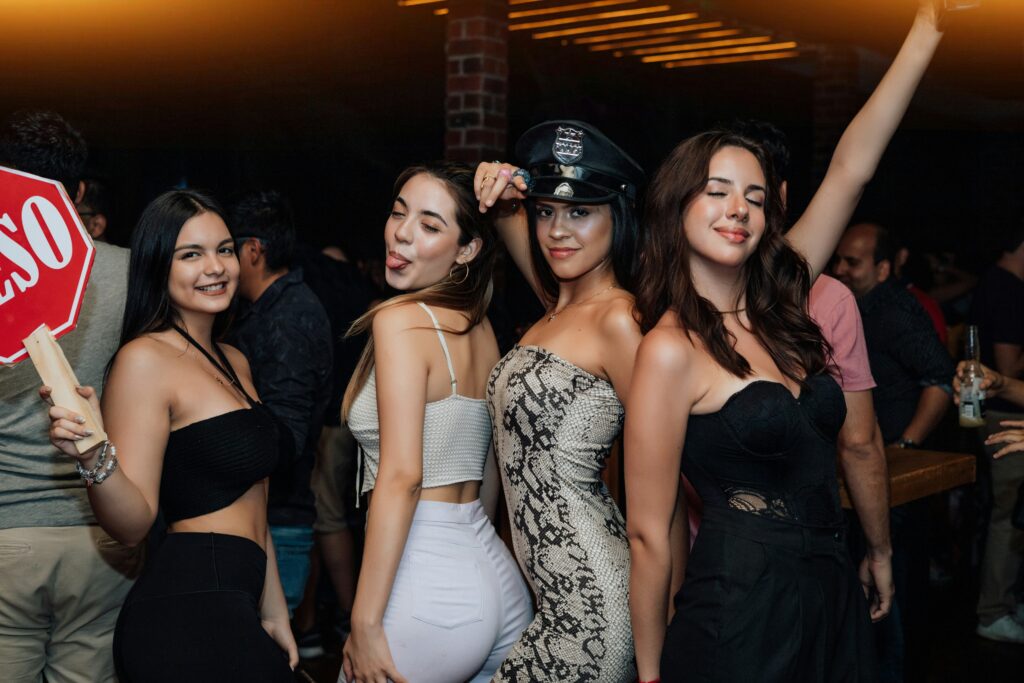 A group of women having fun during a Bartour Hamburg pub crawl, posing playfully and enjoying the nightlife experience