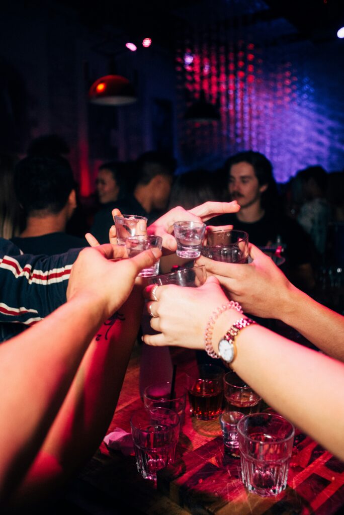 Pubcrawl Crowd toasting with shots during a pub crawl in Hamburg’s Reeperbahn, celebrating the nightlife in St. Pauli.