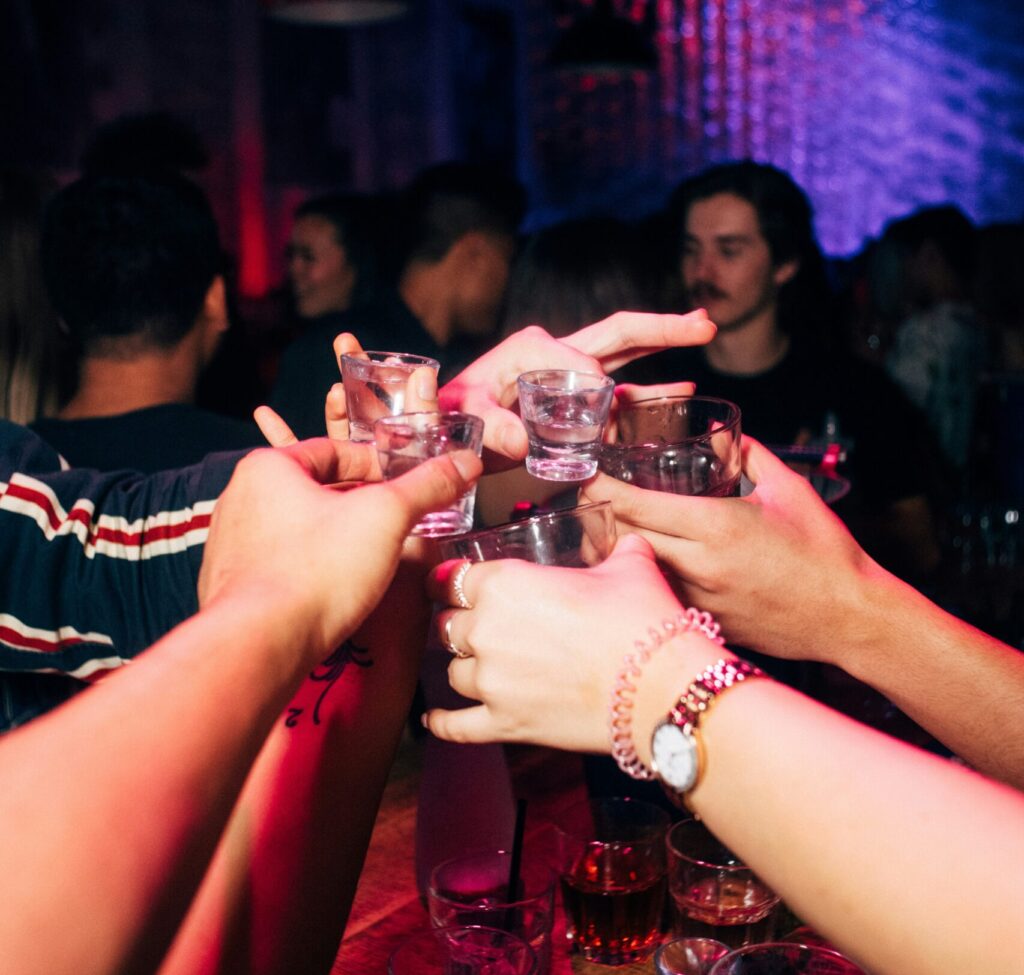 Pubcrawl Crowd toasting with shots during a pub crawl in Hamburg’s Reeperbahn, celebrating the nightlife in St. Pauli.