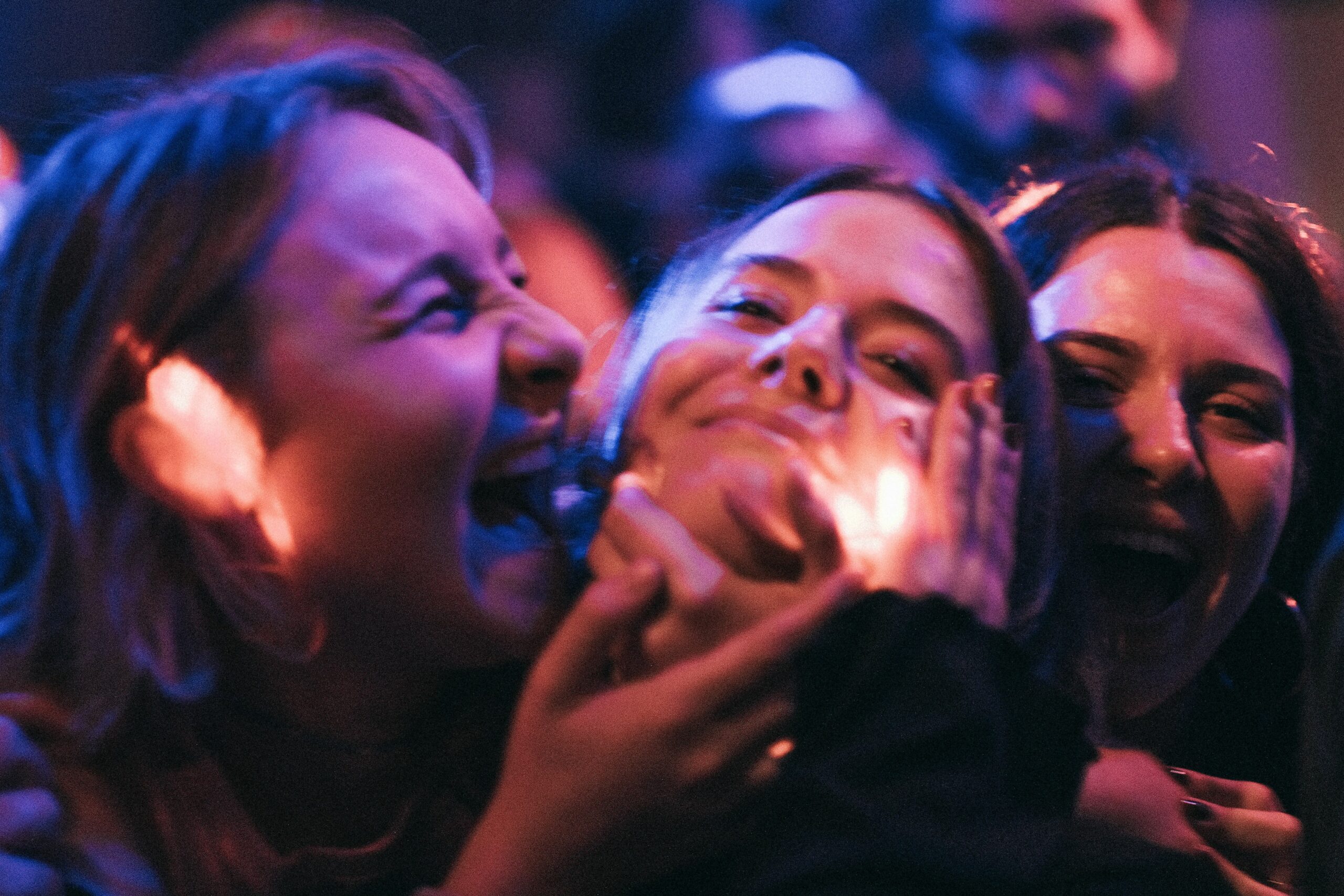 Three women enjoying a night out on the Reeperbahn in Hamburg’s St. Pauli district, celebrating at a themed party with friends