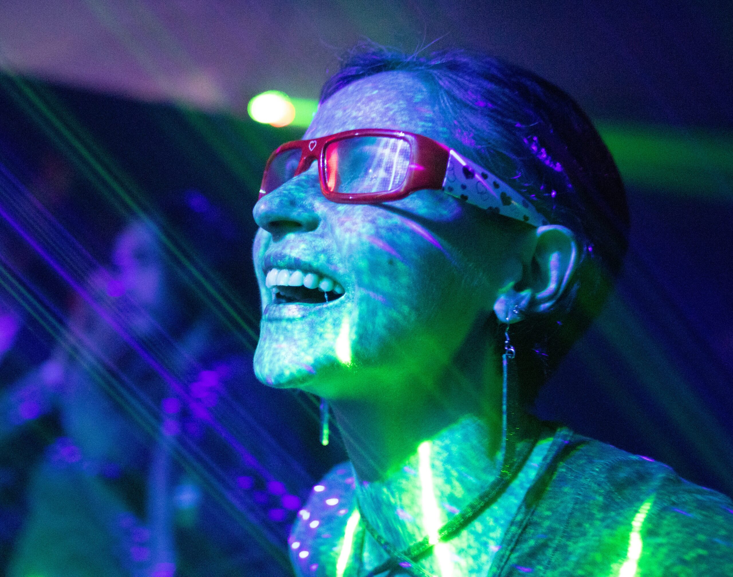 Person enjoying a vibrant laser light show at a pub crawl event on Hamburg’s Reeperbahn, fully immersed in the St. Pauli nightlife.