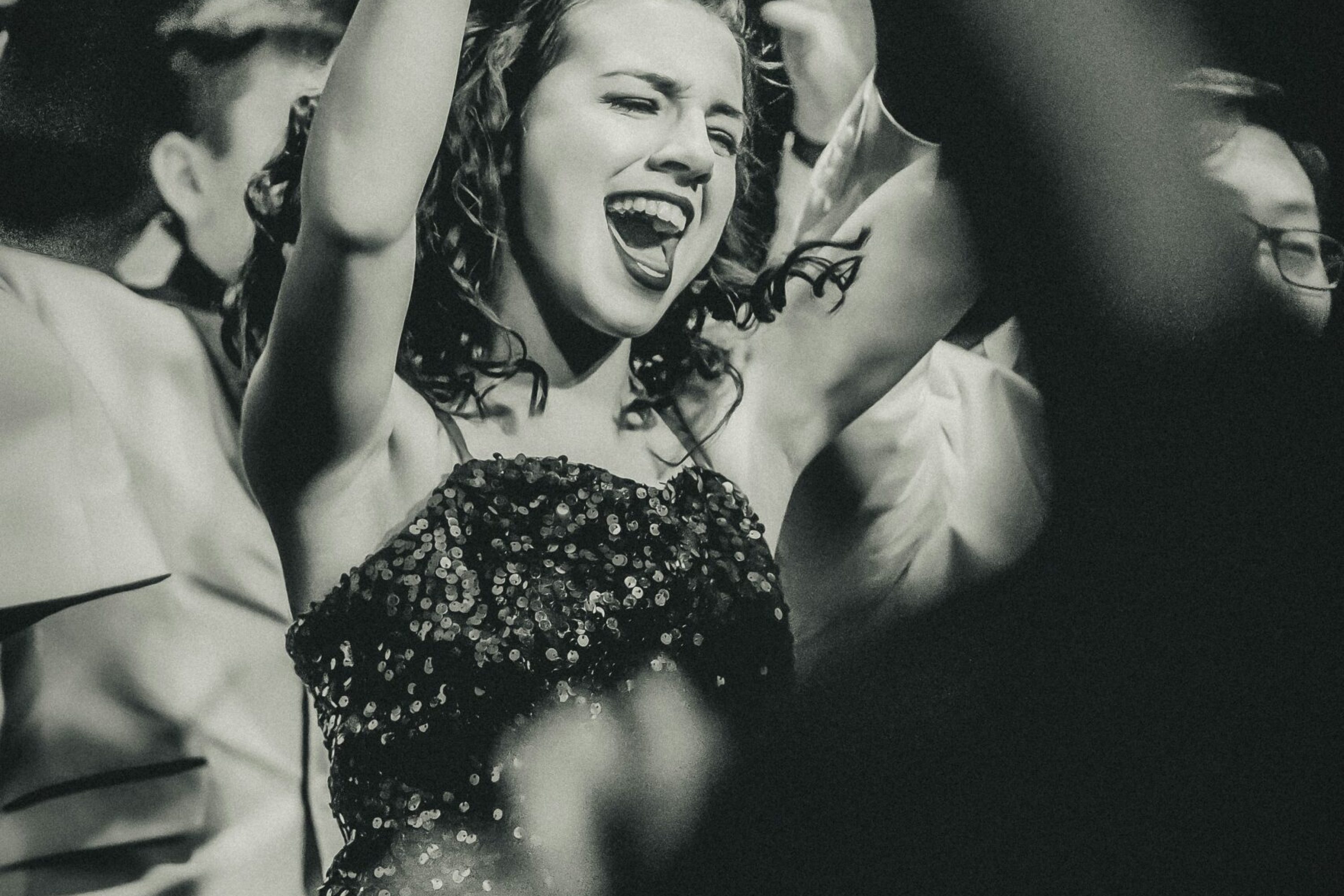 Single Lady joyfully dancing with her hands raised during a lively pub crawl event in Hamburg’s nightlife scene